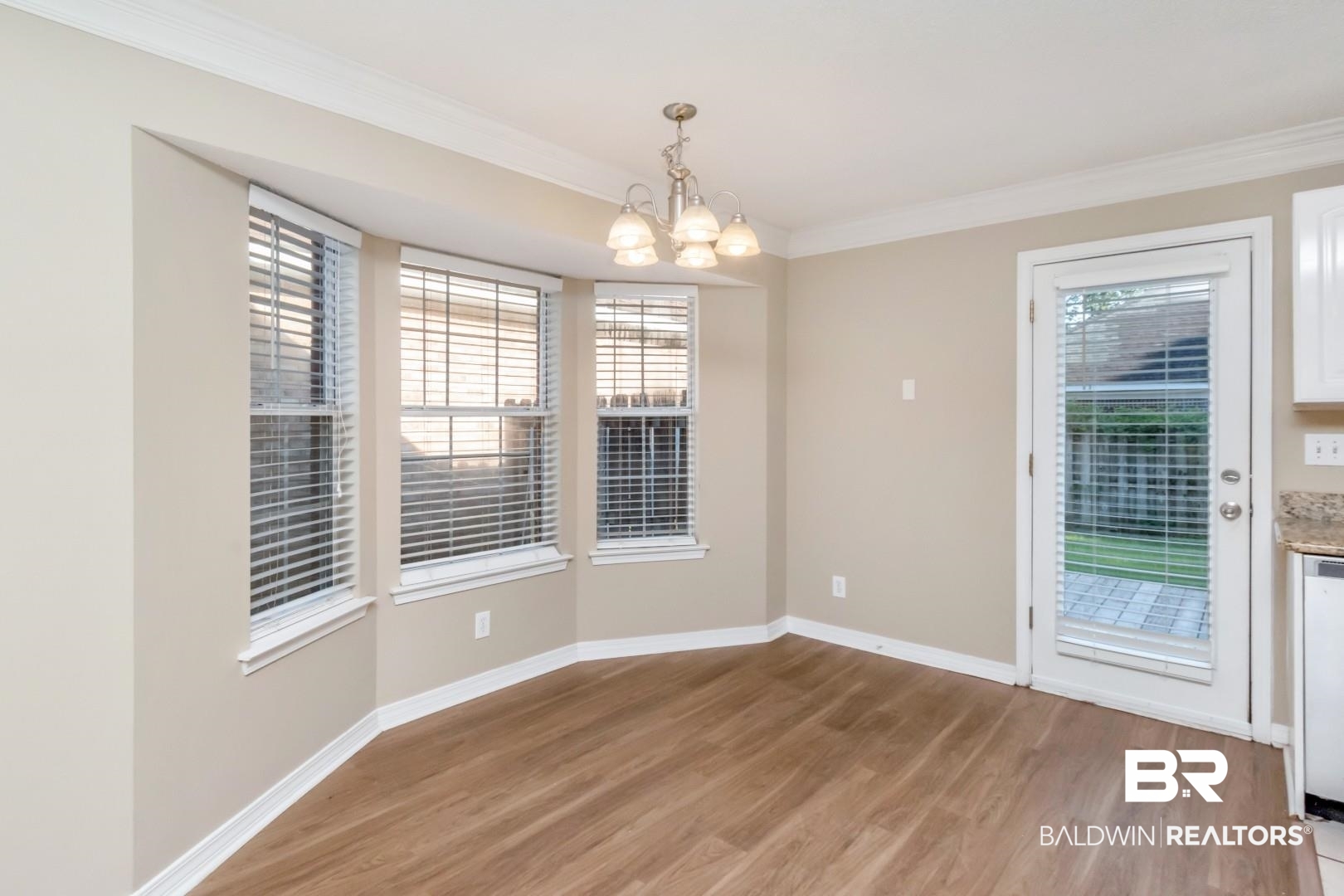 6482 Cedar Bend Court Mobile, AL 36608 - Photo 7 of 26 Unfurnished dining area featuring light wood-style flooring, ornamental molding, and a chandelier
