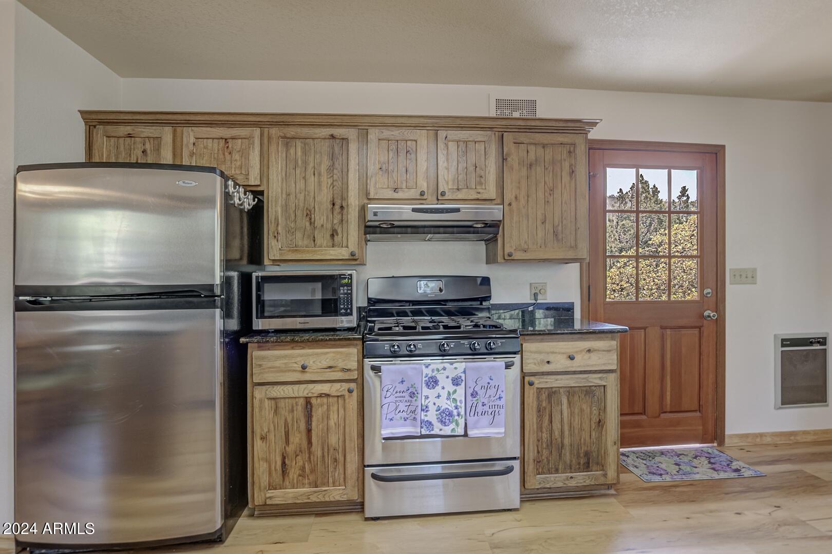 6010 Arroyo Way Pine, AZ 85544 - Photo 11 of 52 a kitchen with stainless steel appliances granite countertop a stove and a refrigerator