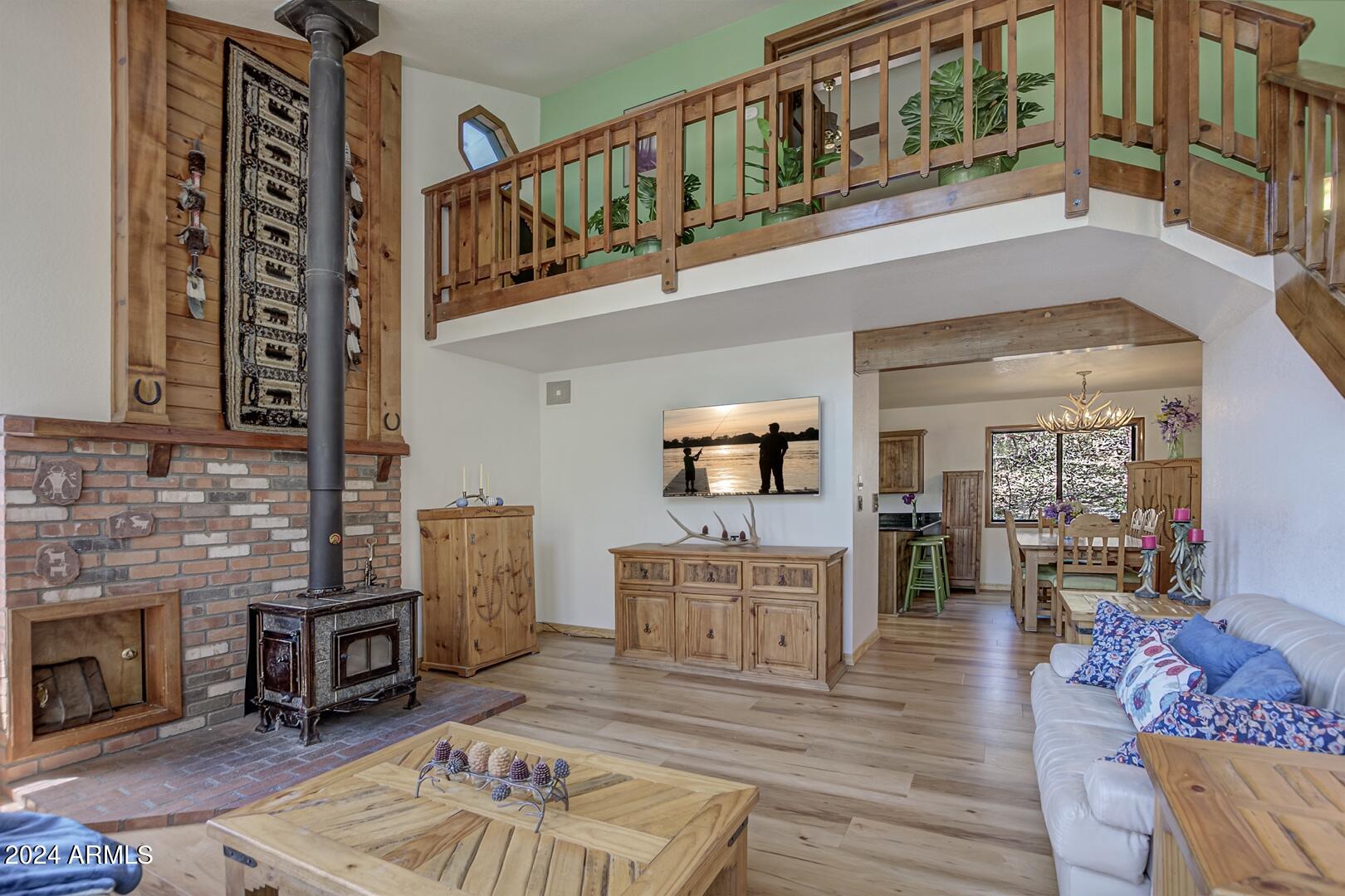 6010 Arroyo Way Pine, AZ 85544 - Photo 5 of 52 a living room with furniture a fireplace and a wooden floor