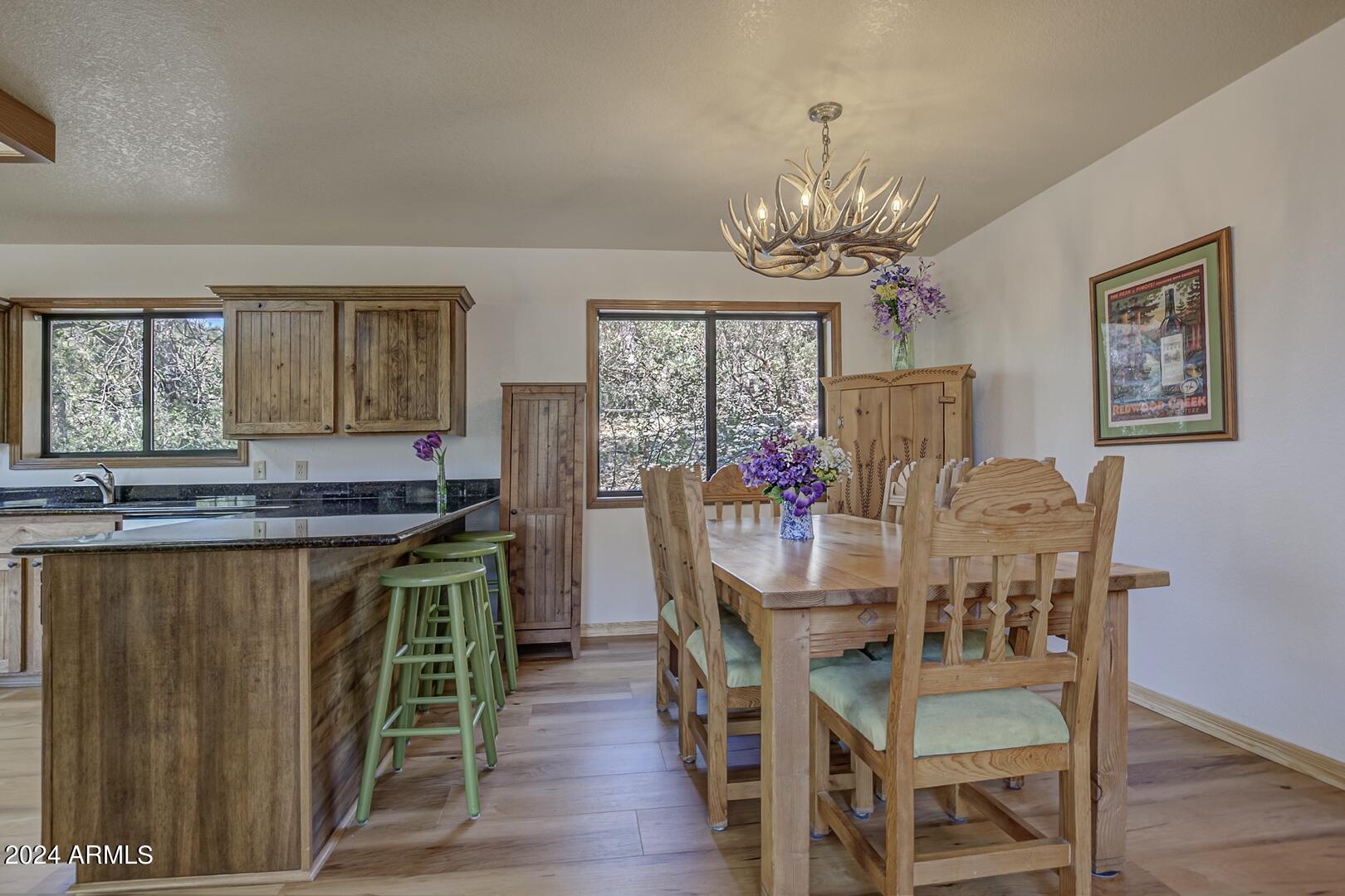 6010 Arroyo Way Pine, AZ 85544 - Photo 7 of 52 a view of a dining room with furniture a chandelier and wooden floor