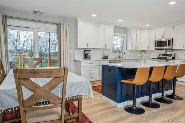 a kitchen with granite countertop a stove a sink and a refrigerator