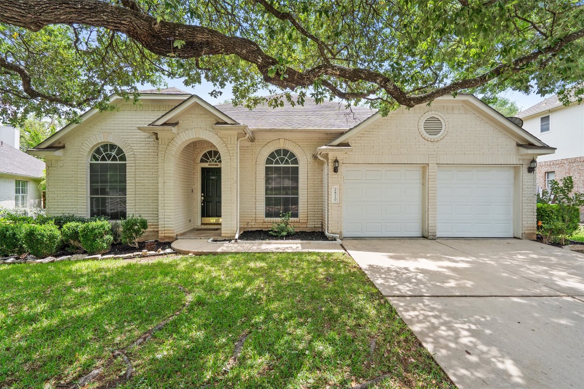 a front view of a house with a garden and yard