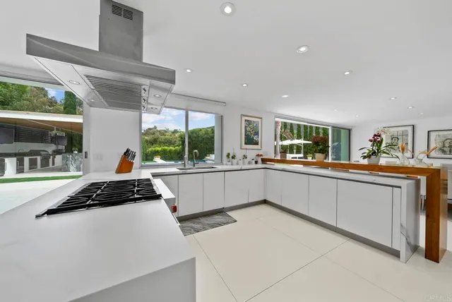 a kitchen with stainless steel appliances kitchen island sink stove and cabinets