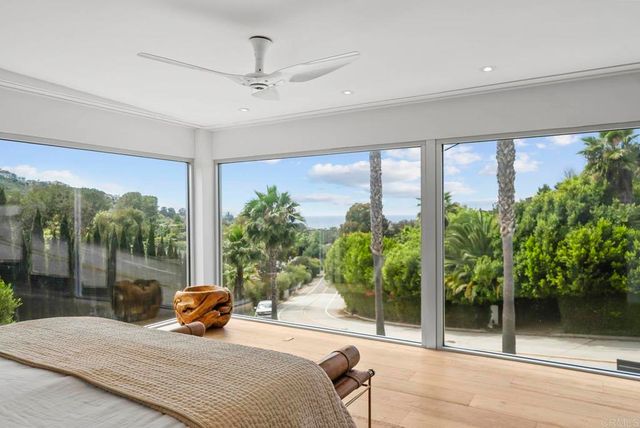 a bedroom with furniture and large windows