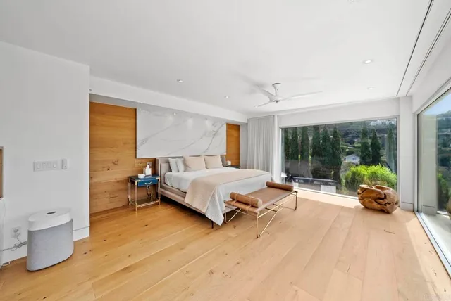 a spacious bedroom with a bed and a large window