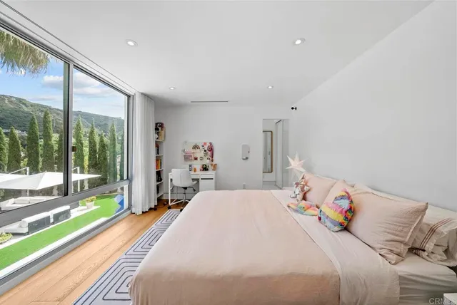 a bedroom with a bed and large windows