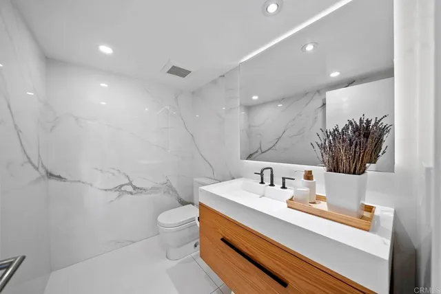 a bathroom with a sink a toilet and mirror