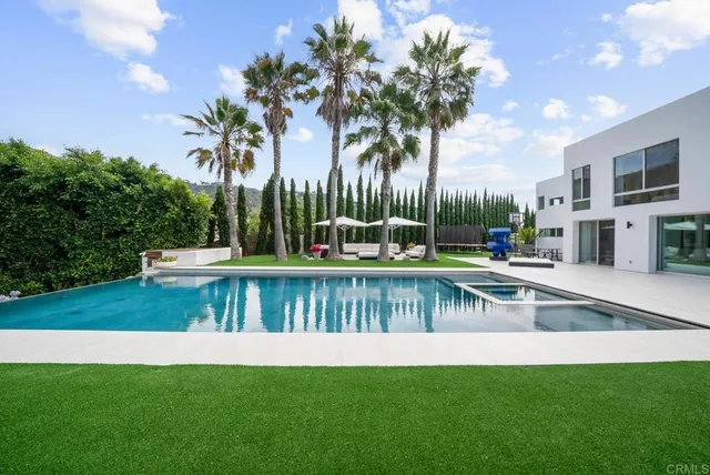 a view of a house with swimming pool and a yard