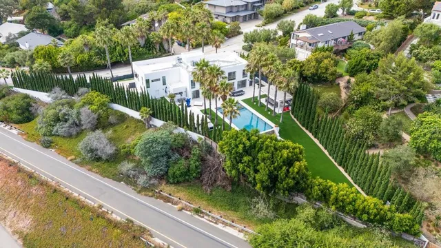 an aerial view of a house with swimming pool garden and patio