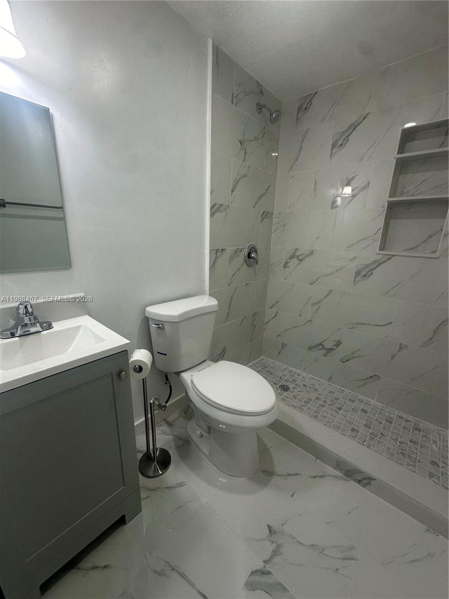 2753 West 68th Place, Unit 1 Hialeah, FL 33016 - Photo 12 of 13 a bathroom with a toilet sink and mirror