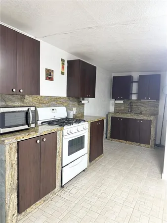 a kitchen with stainless steel appliances granite countertop a sink stove and cabinets