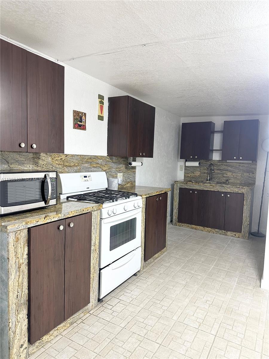 2753 West 68th Place, Unit 1 Hialeah, FL 33016 - Photo 8 of 13 a kitchen with stainless steel appliances granite countertop a sink stove and cabinets