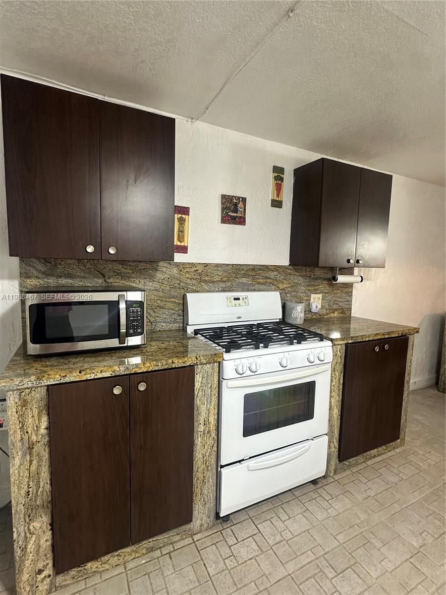 2753 West 68th Place, Unit 1 Hialeah, FL 33016 - Photo 9 of 13 a kitchen with stainless steel appliances granite countertop a stove a sink and a microwave