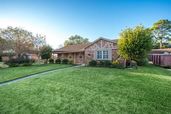 a front view of a house with yard and green space