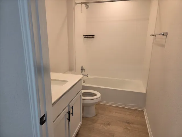 a bathroom with a granite countertop sink a toilet and shower