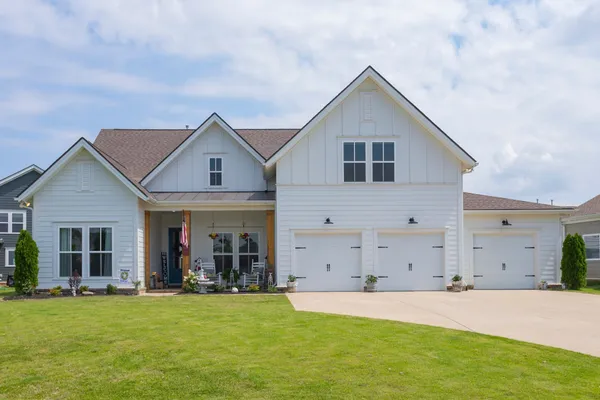 a front view of house with yard and trees in the background