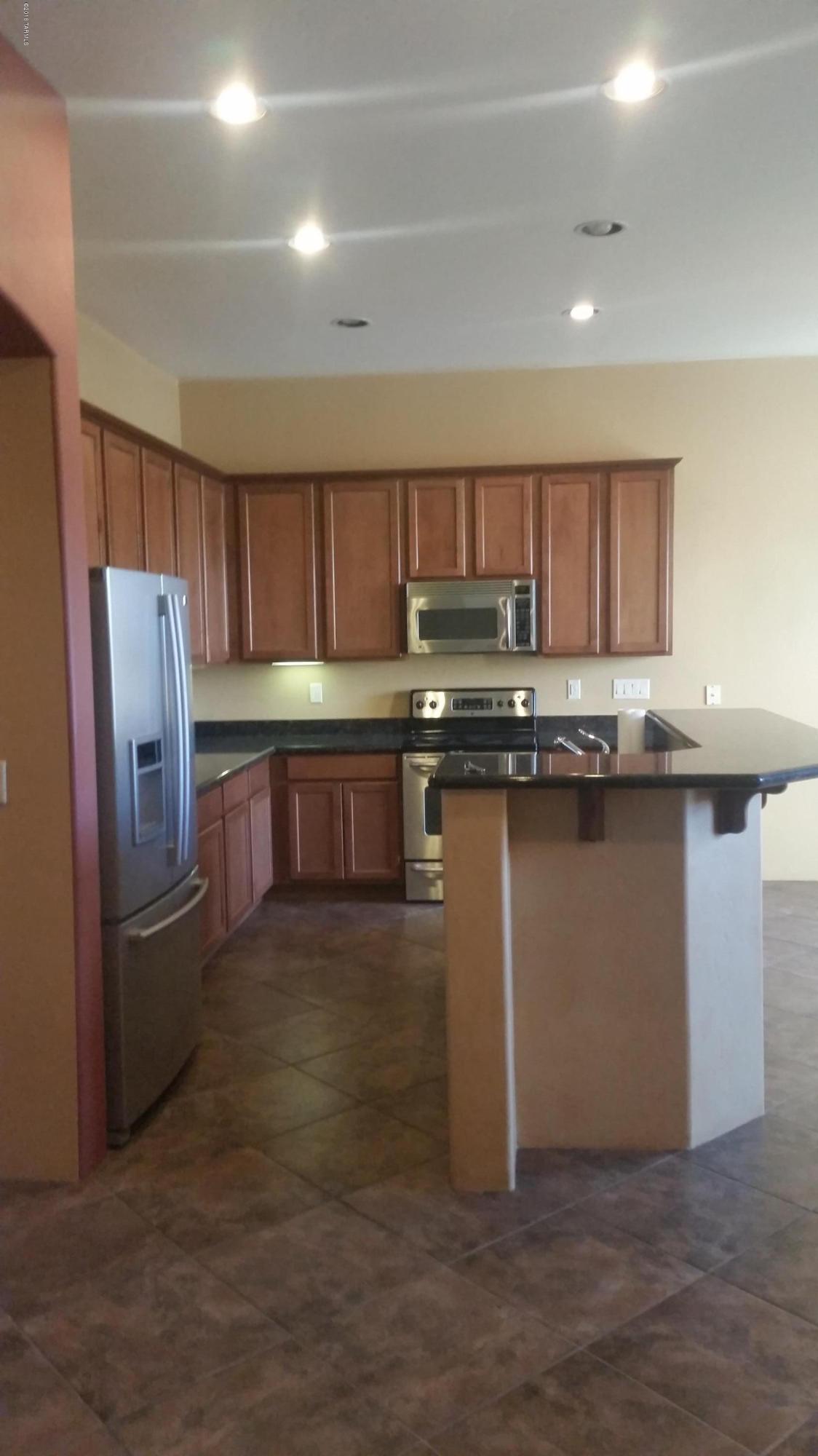478 East Cedarvale Road Tucson, AZ 85704 - Photo 3 of 39 a kitchen with stainless steel appliances granite countertop a refrigerator a sink a stove a microwave and wooden cabinets