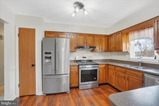 a kitchen with granite countertop a sink cabinets and wooden floor