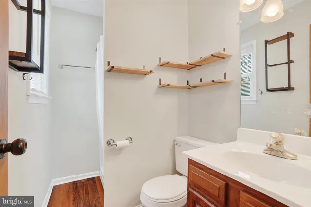 an empty room with chandelier fan and windows