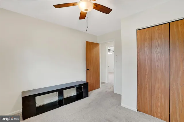 an empty room with window and a ceiling fan