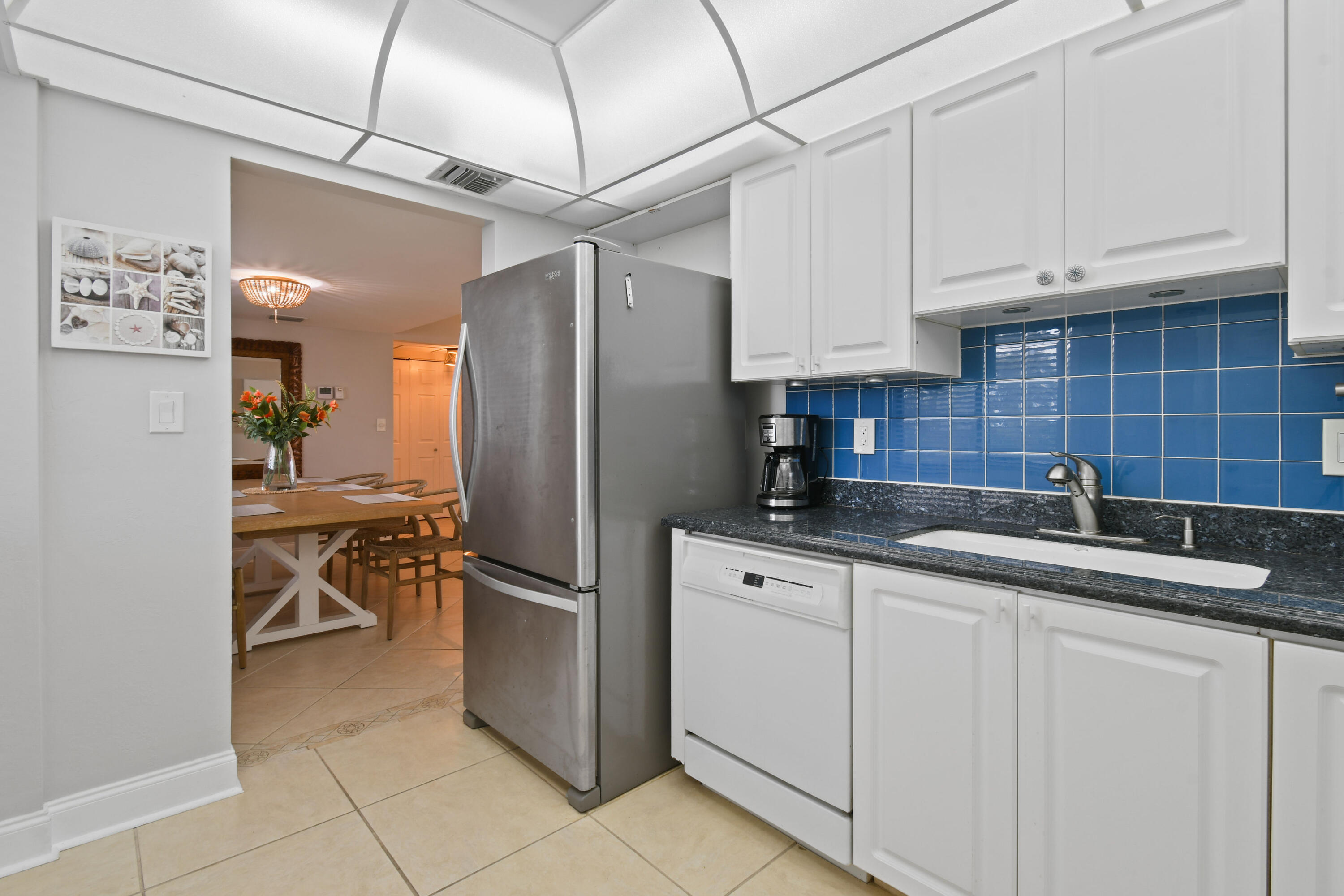 1605 Highway 1, Unit M1404 Jupiter, FL 33477 - Photo 18 of 42 a kitchen with stainless steel appliances granite countertop a sink refrigerator and cabinets