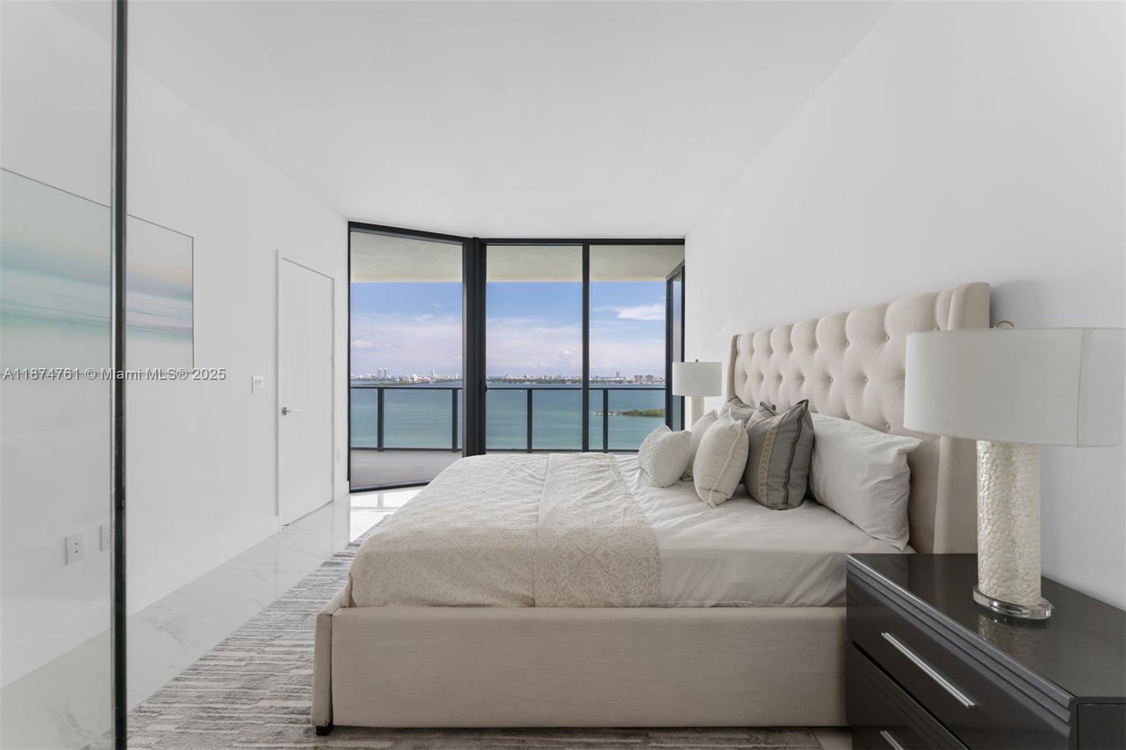700 Northeast 24th Street, Unit 2201 Miami, FL 33137 - Photo 7 of 20 a bedroom with a large bed and a night stand