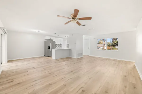 a view of empty room with wooden floor and ceiling fan