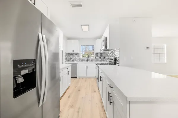 a kitchen with a sink a refrigerator and cabinets
