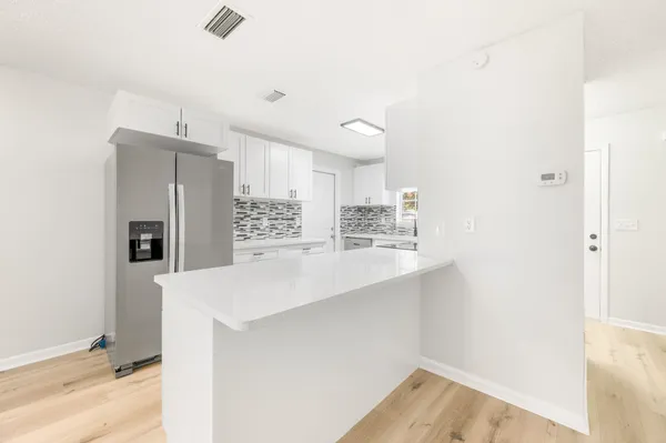 a view of kitchen with refrigerator sink and wooden floor