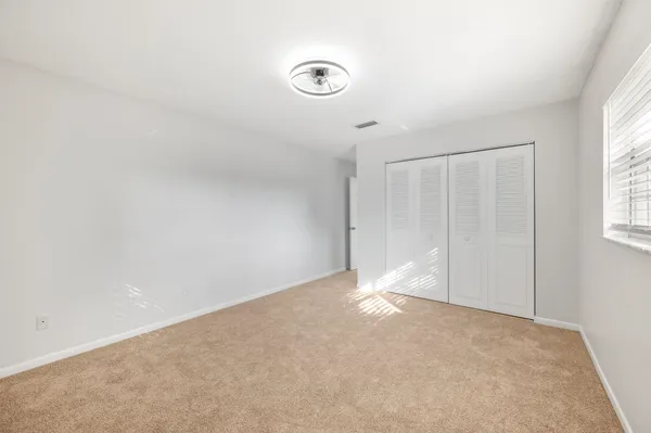 an empty room with windows and closet