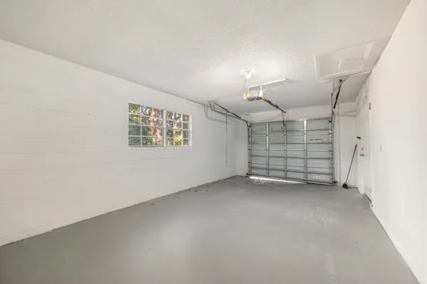 an empty room with windows and ceiling fan