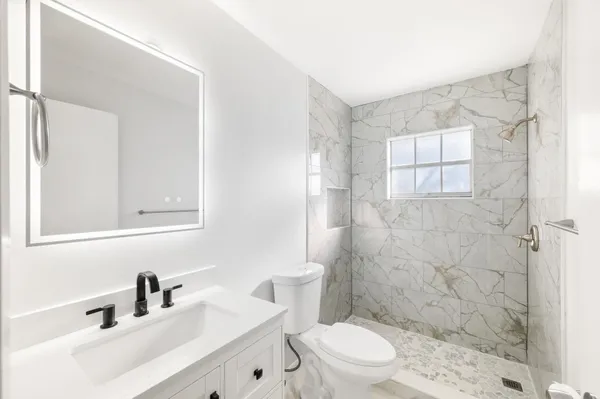 a bathroom with a sink a toilet and shower