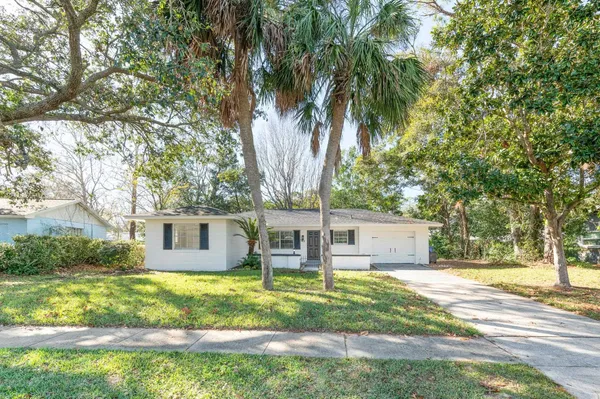 a view of a house with a backyard and a tree