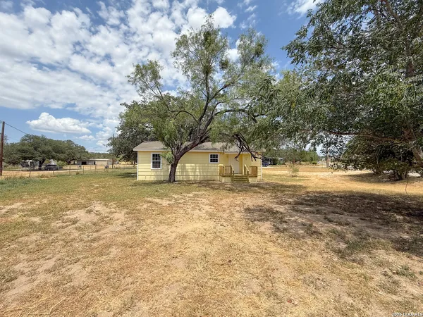 a front view of a house with a yard and trees