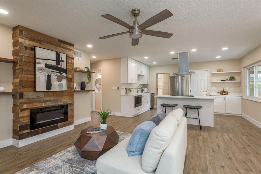2480 Del Rio Way Dunedin, FL 34698 - Photo 6 of 35 a living room with furniture kitchen view and a fireplace