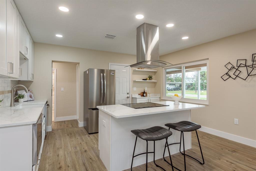 2480 Del Rio Way Dunedin, FL 34698 - Photo 8 of 35 a kitchen with stainless steel appliances a sink a stove a refrigerator cabinets and wooden floor