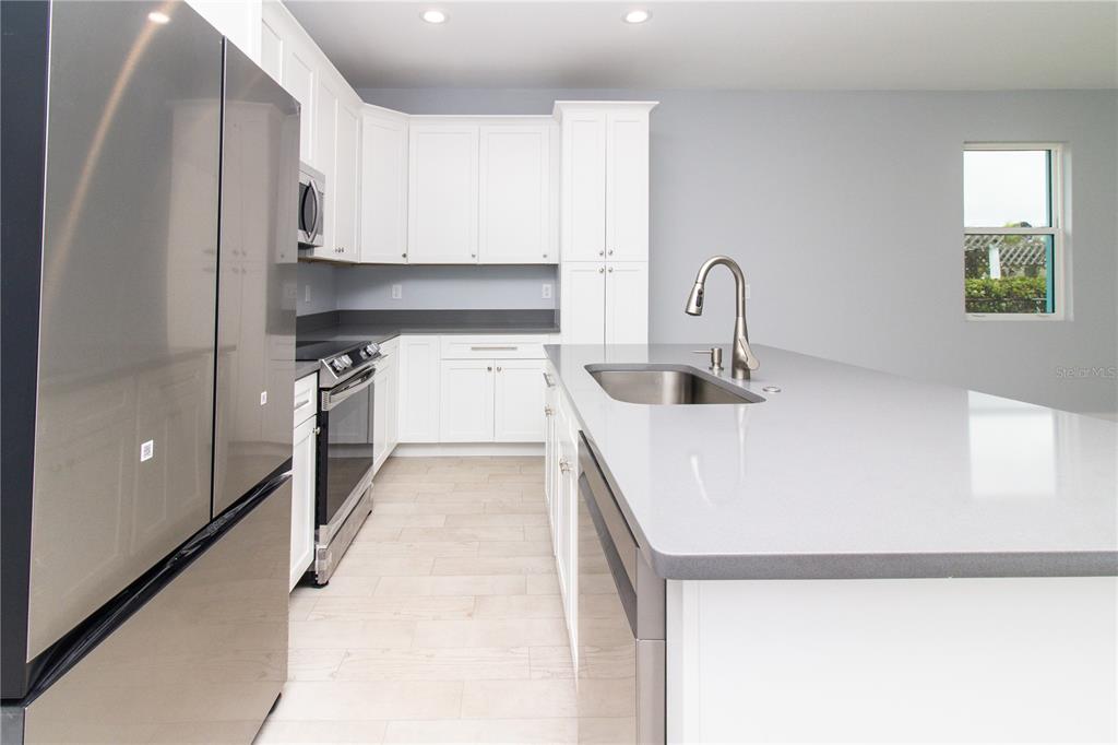 113 Douglas Street Edgewater, FL 32141 - Photo 16 of 39 a kitchen with stainless steel appliances granite countertop a sink a stove and a refrigerator