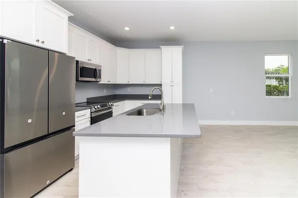 a kitchen with stainless steel appliances a stove microwave and sink