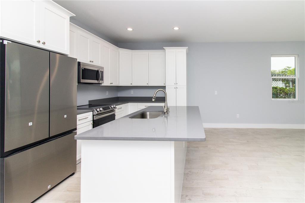 113 Douglas Street Edgewater, FL 32141 - Photo 17 of 39 a kitchen with stainless steel appliances a sink a stove a microwave a refrigerator a sink and a cabinets