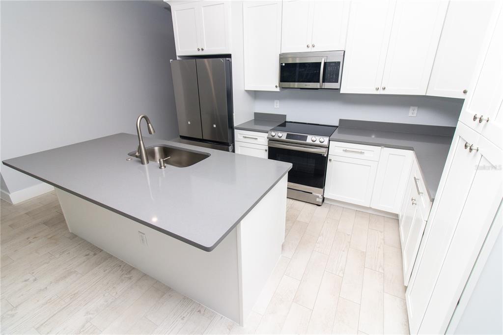113 Douglas Street Edgewater, FL 32141 - Photo 18 of 39 a kitchen with stainless steel appliances a stove microwave and sink
