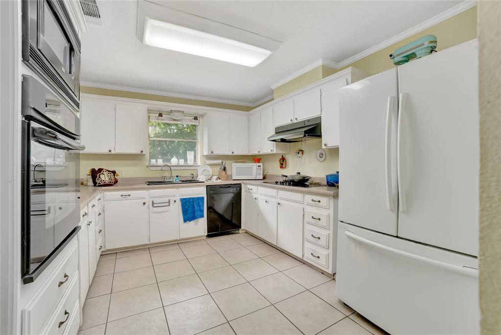 6021 Sycamore Creek Road Edgecliff Village, TX 76134 - Photo 13 of 37 Kitchen with black appliances, under cabinet range hood, ornamental molding, a sink, and light tile patterned flooring