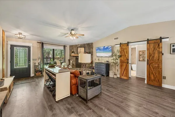 a living room with furniture kitchen view and a chandelier