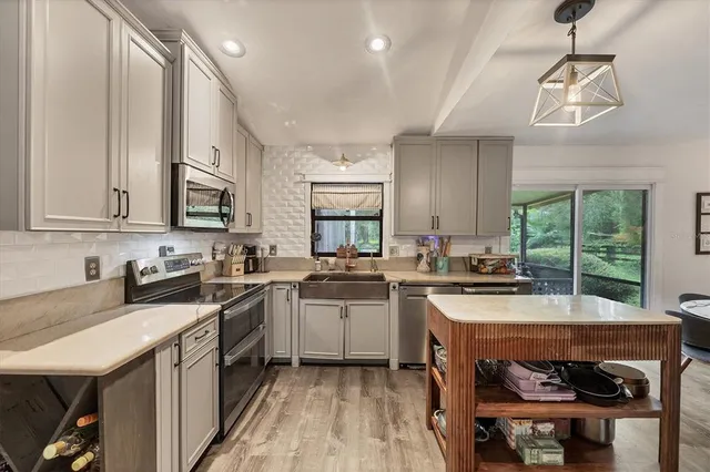a kitchen with stainless steel appliances a stove sink microwave and cabinets