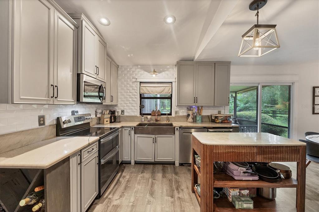 18155 Highway 62 Parrish, FL 34219 - Photo 16 of 61 a kitchen with a sink a stove a refrigerator and chairs