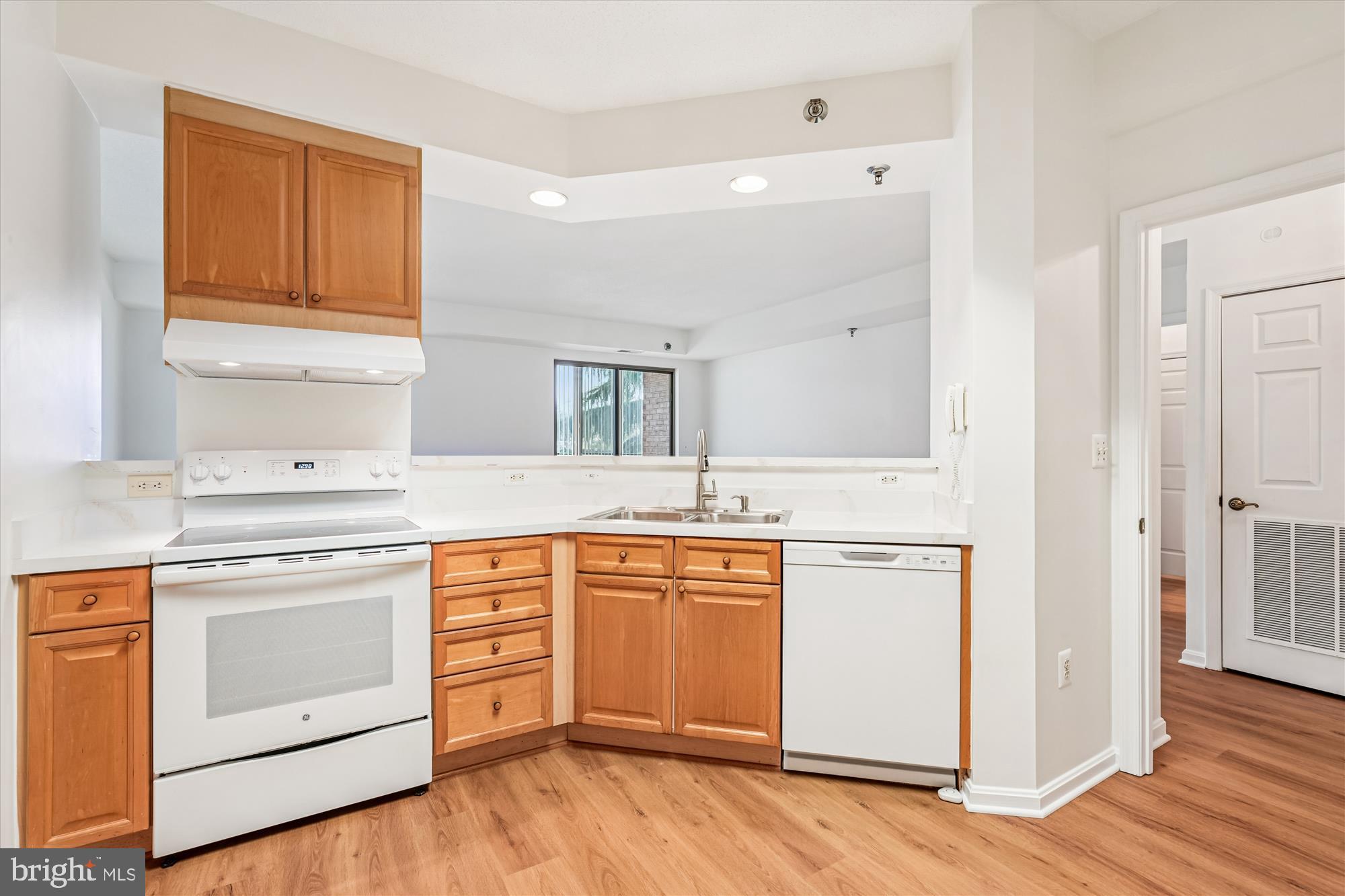 3210 North Leisure World Boulevard, Unit 119 Silver Spring, MD 20906 - Photo 15 of 76 a kitchen with stainless steel appliances white cabinets and wooden floor