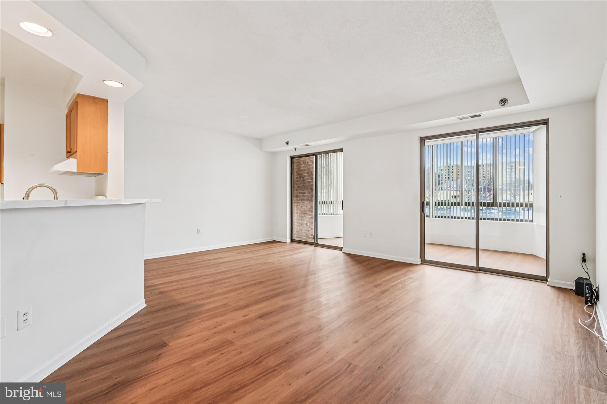 3210 North Leisure World Boulevard, Unit 119 Silver Spring, MD 20906 - Photo 17 of 76 an empty room with wooden floor and windows