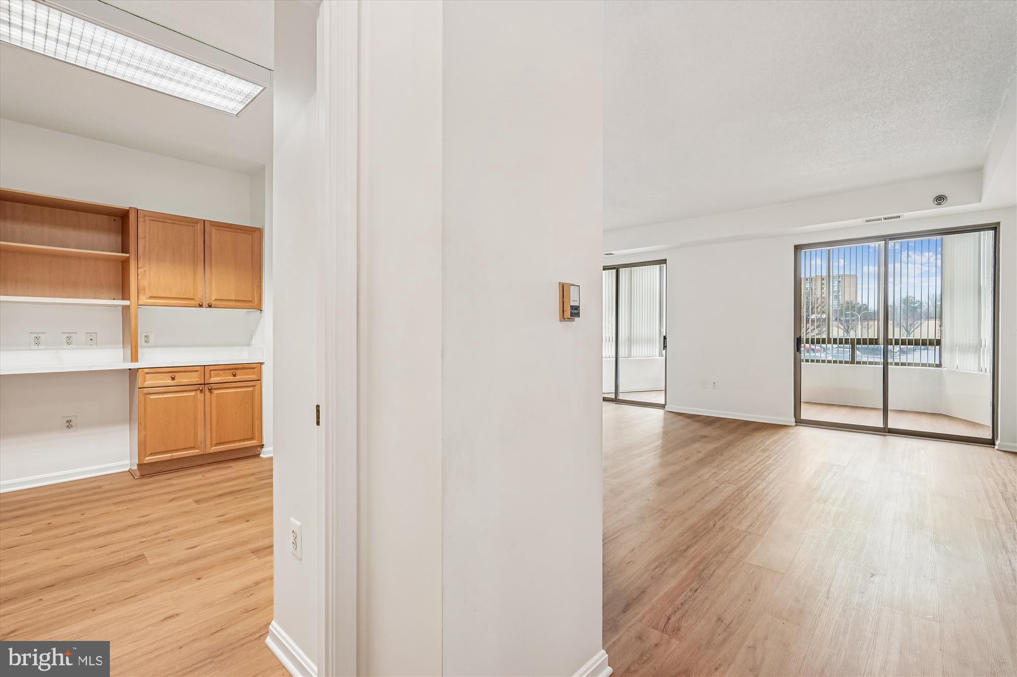 3210 North Leisure World Boulevard, Unit 119 Silver Spring, MD 20906 - Photo 23 of 76 a view of an empty room with wooden floor and a window