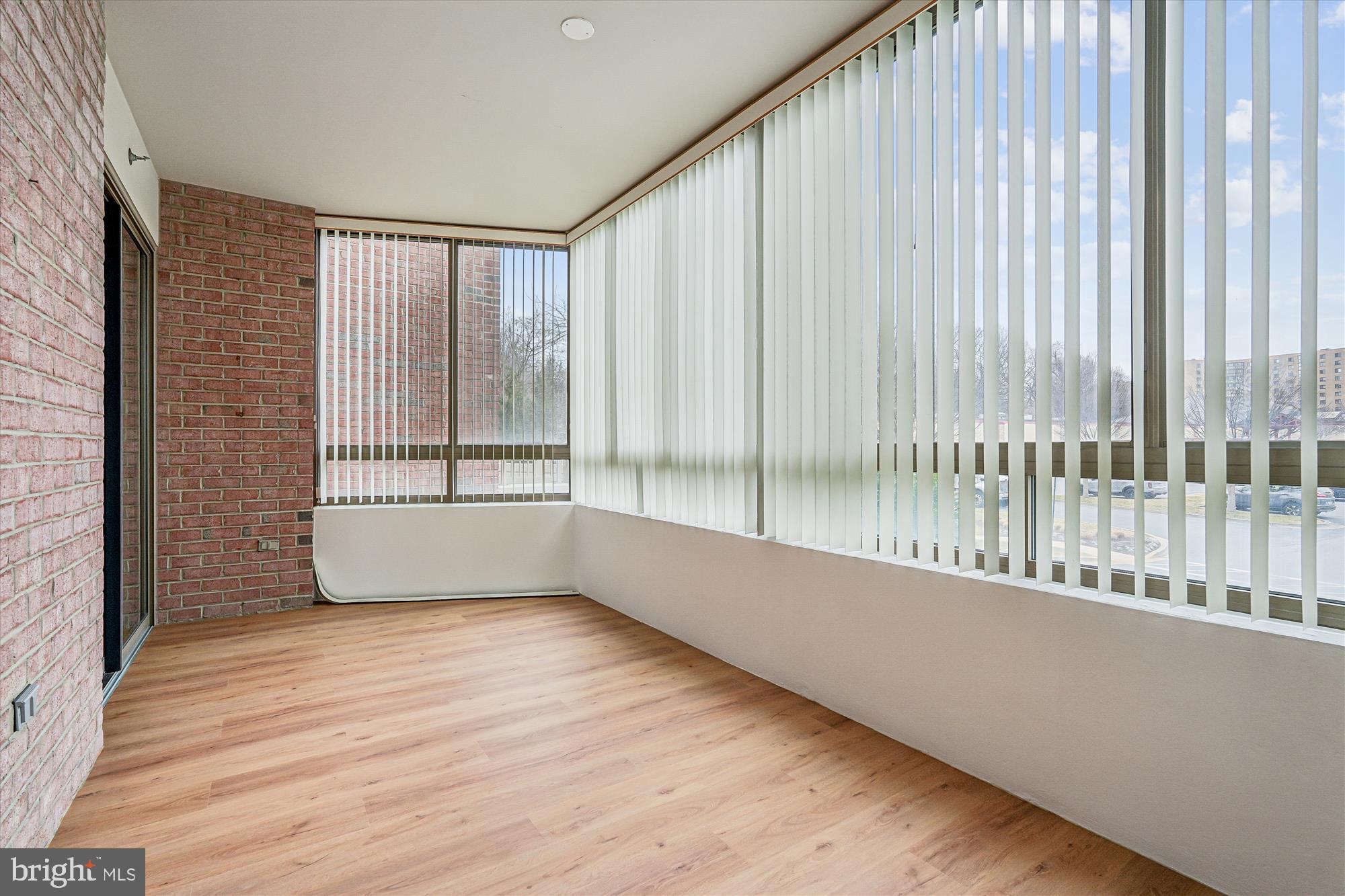 3210 North Leisure World Boulevard, Unit 119 Silver Spring, MD 20906 - Photo 26 of 76 a view of an empty room with wooden floor and a window