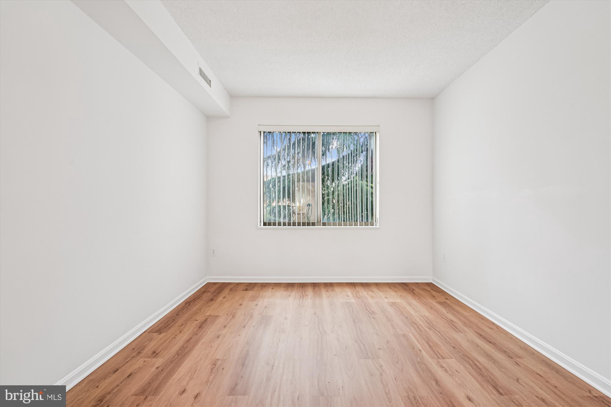 3210 North Leisure World Boulevard, Unit 119 Silver Spring, MD 20906 - Photo 34 of 76 an empty room with wooden floor and windows