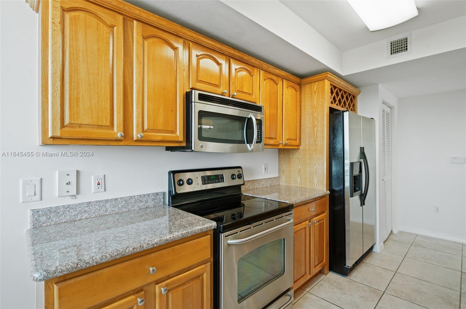 3530 Southwest 22nd Street, Unit 713 Miami, FL 33145 - Photo 24 of 41 a kitchen with stainless steel appliances granite countertop a stove a sink and a microwave
